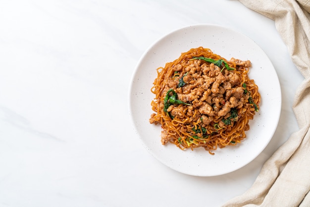 fideos instantáneos salteados con albahaca tailandesa y carne picada de cerdo - estilo de comida asiática