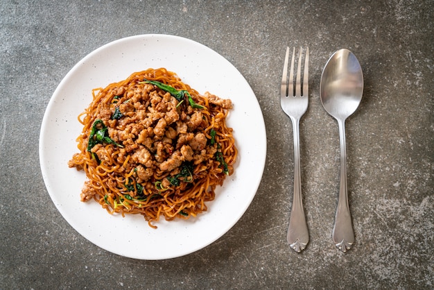 fideos instantáneos salteados con albahaca tailandesa y carne picada de cerdo - estilo de comida asiática