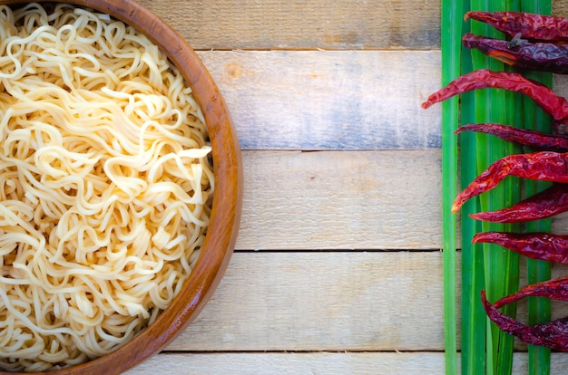 Fideos instantáneos en taza de madera en el fondo de madera, estilo tailandés de la comida.