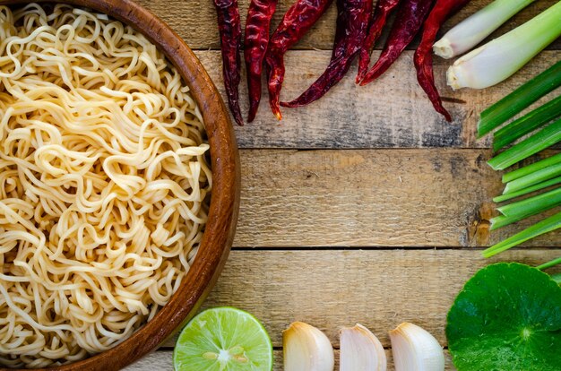 Fideos instantáneos en taza de madera en el fondo de madera, estilo tailandés de la comida.