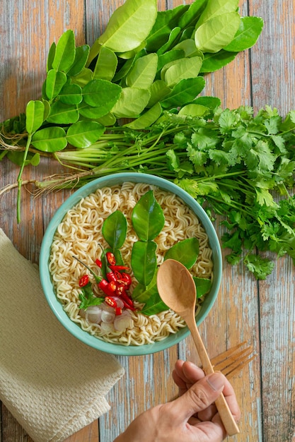 Fideos instantáneos con verduras frescas sobre fondo de madera fastfood