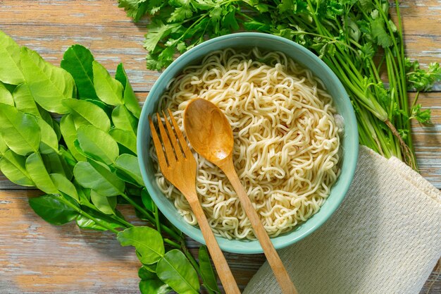 Fideos instantáneos con verduras frescas sobre fondo de madera fastfood