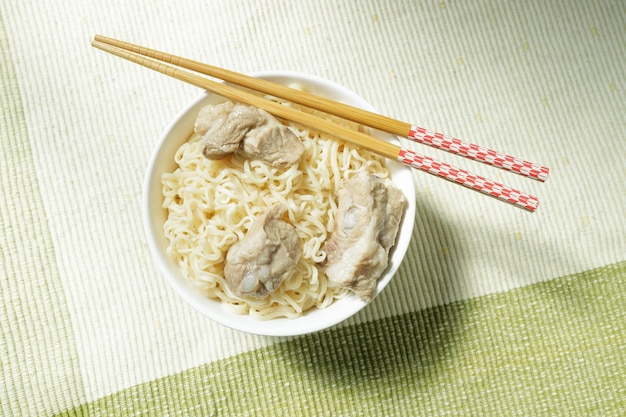 Foto fideos de mamá en un tazón blanco con palillos