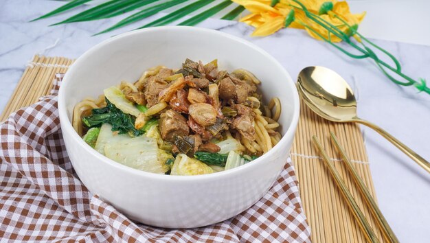 Fideos mie ayam de comida indonesia con pollo Servido en tazón Enfoque selectivo