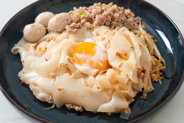 Fideos picantes secos con albóndigas de cerdo picadas y huevo