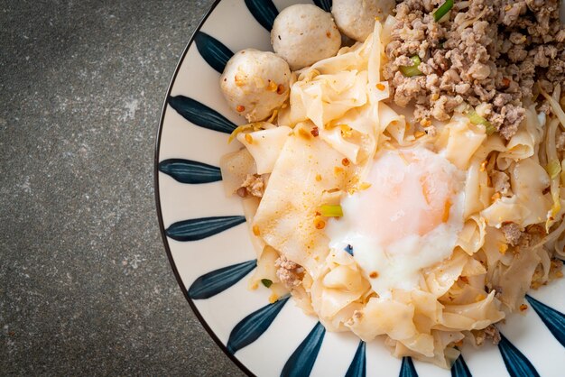 Fideos picantes secos con albóndigas de cerdo picadas y huevo