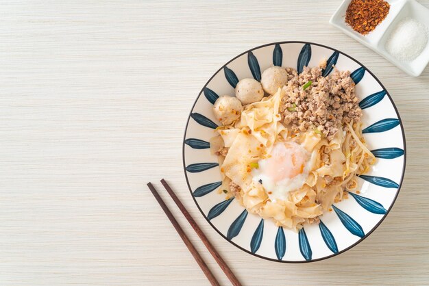 Fideos picantes secos con albóndigas de cerdo picadas y huevo