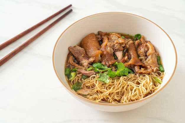 Fideos de pierna de cerdo guisados en sopa marrón - estilo de comida asiática