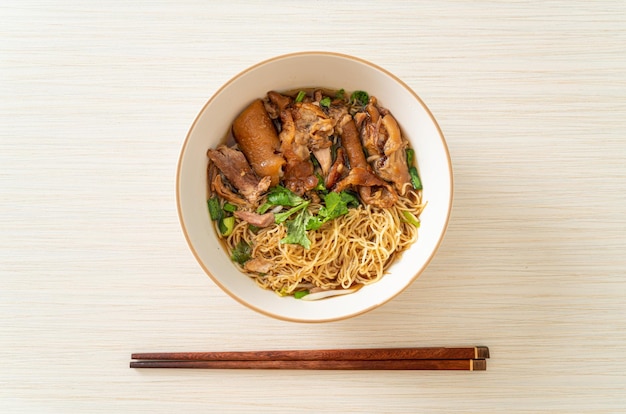 Fideos de pierna de cerdo guisados en sopa marrón - estilo de comida asiática