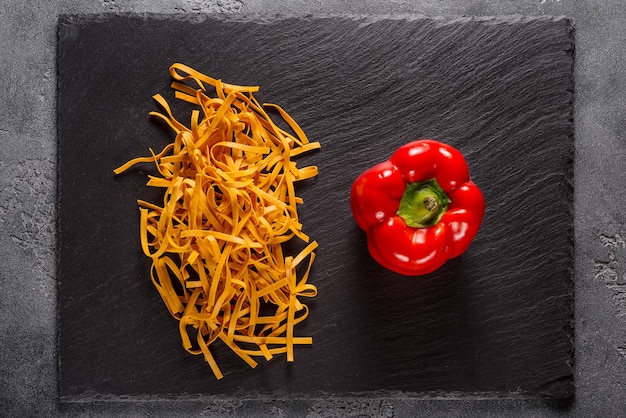 Fideos con pimentón y huevo rojo sobre piedra negra