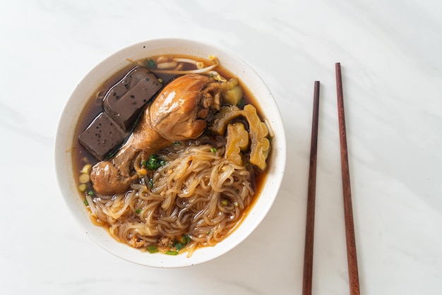 Fideos de pollo guisados en tazón de sopa marrón - estilo de comida asiática