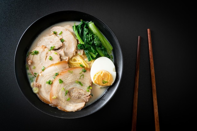 Fideos ramen en sopa de hueso de cerdo con cerdo asado y huevo o fideos ramen Tonkotsu - estilo de comida japonesa