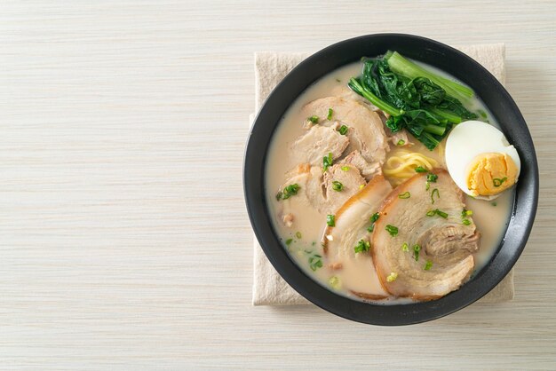 Fideos ramen en sopa de hueso de cerdo con cerdo asado y huevo o fideos ramen Tonkotsu - estilo de comida japonesa