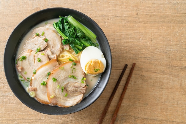 Fideos ramen en sopa de hueso de cerdo con cerdo asado y huevo o fideos ramen Tonkotsu - estilo de comida japonesa