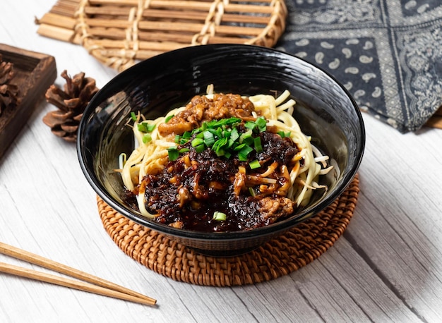 Fideos con salsa de chile grande en un plato aislado en la vista lateral de la mesa de madera comida de taiwán