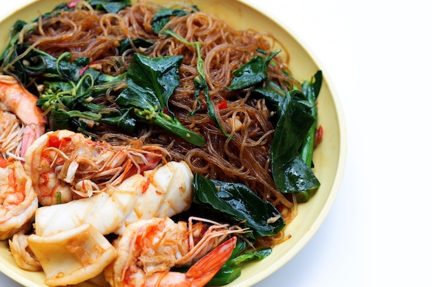 Fideos salteados picantes con hojas de albahaca sagrada y mariscos