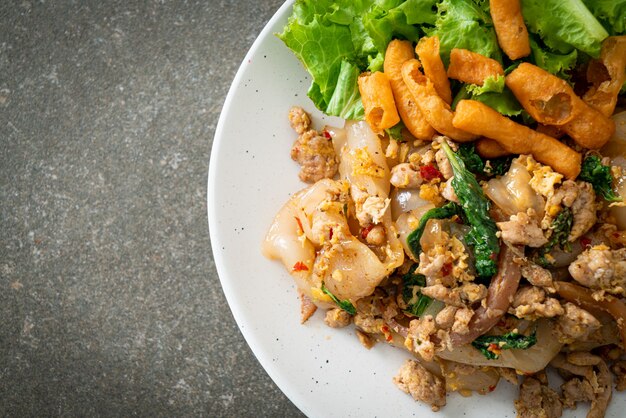 Fideos salteados con pollo picado y albahaca - estilo de comida asiática