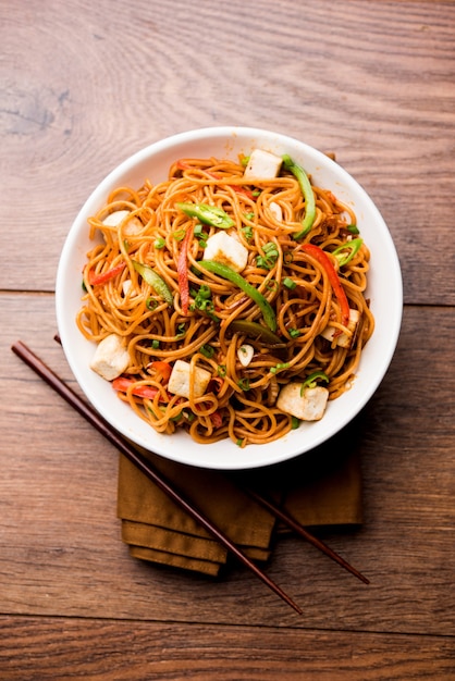 Fideos Schezwan hakka con paneer o requesón. Servido en un bol. enfoque selectivo