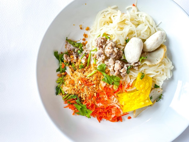 Fideos secos estilo comida tailandesa sobre fondo blanco.