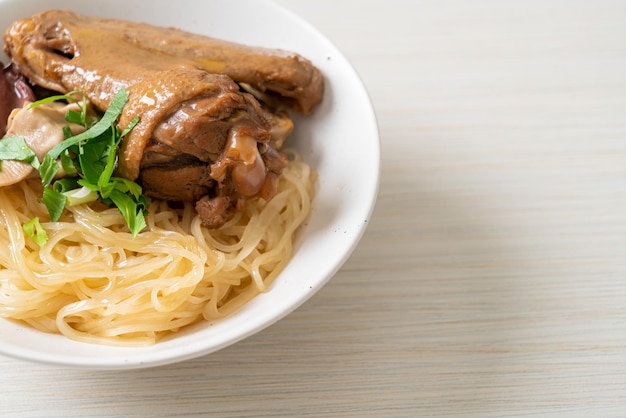 fideos secos con pato estofado en tazón blanco - estilo de comida asiática