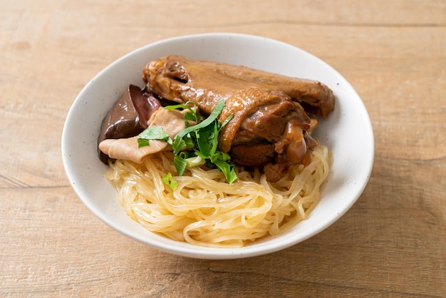 Fideos secos con pato estofado en tazón blanco