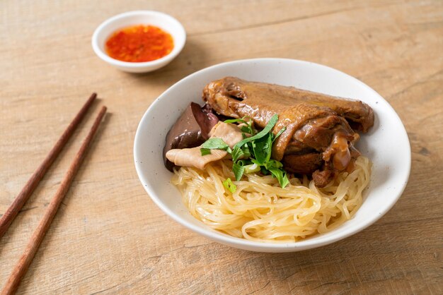 Fideos secos con pato estofado en tazón blanco