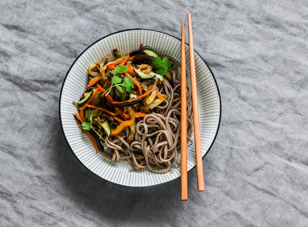 Fideos de soba vegetarianos con verduras salteadas delicioso almuerzo de estilo asiático en una vista superior de fondo gris