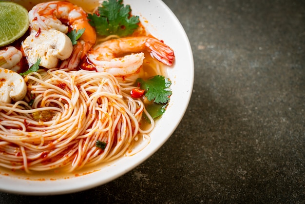 Fideos con sopa picante y camarones en tazón de fuente blanco