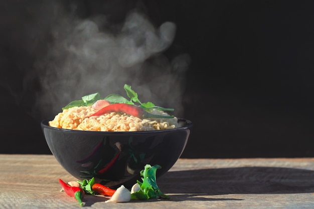 fideos en un tazón con vapor y humo en el bosque y la luz de la mañana