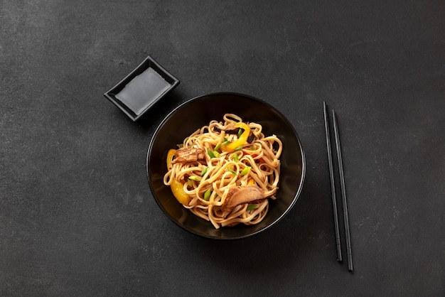 Fideos udon en un plato negro sobre un fondo oscuro cocina asiática