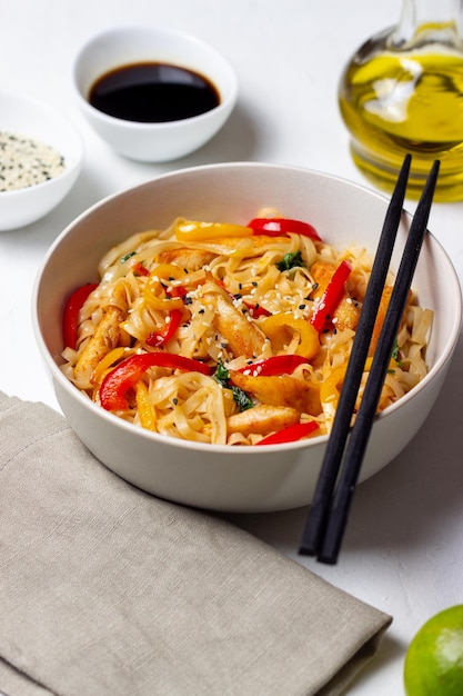 Fideos udon con pollo, pimiento y sésamo. Comida china.