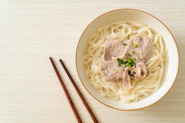 Fideos udon ramen caseros con carne de cerdo en sopa clara