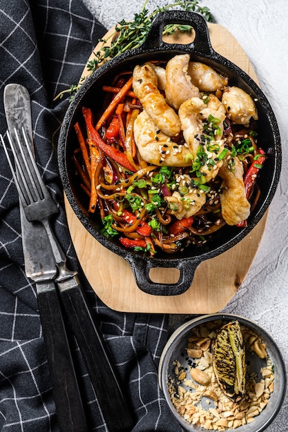 Fideos udon salteados con pollo y verduras en sartén