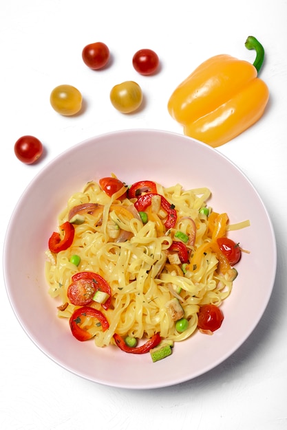 Fideos veganos con guisantes, pimientos, cebolla y calabacín