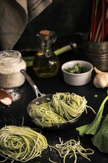 Fideos de vegetales verdes asiáticos crudos caseros en el proceso de cocción casera en la cocina Mie Sawi Sayur