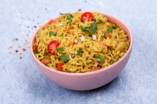 Fideos con verduras en un tazón rosa