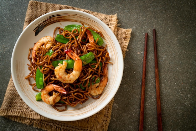 fideos yakisoba salteados con guisantes y camarones - estilo de comida asiática