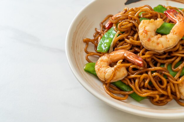 Fideos yakisoba salteados con guisantes y gambas - Estilo de comida asiática