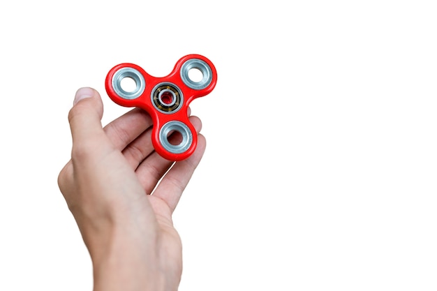 Fidget spinner. Roter Handspinner, zappelndes Handspielzeug, das auf Kinderhand rotiert. Entspannung. Anti Stress und Entspannung und Aufmerksamkeit Modeerscheinung Junge Konzept. Freier Platz für Text.