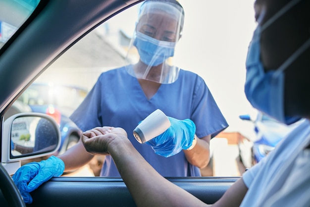 Fiebertemperatur und Covid-Test an der Durchfahrtsstation in einem Auto Professionelle Krankenschwester oder Arzt untersucht Patienten mit einem Thermometer Wellness und Sicherheit von Menschen während einer Pandemie