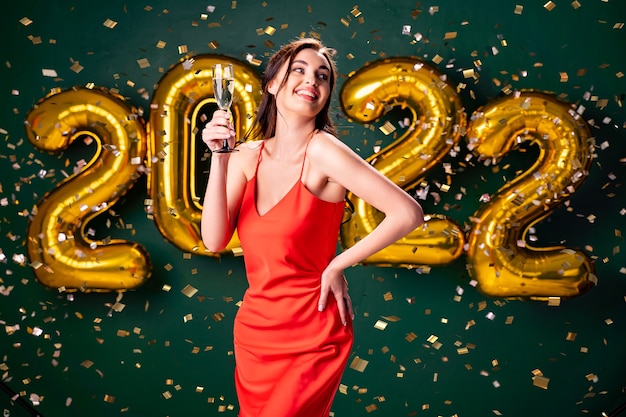 Fiesta de año nuevo globos de aire confeti fondo verde mujer con champagne celebrar