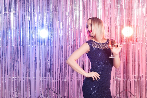 Fiesta, bebidas, vacaciones y concepto de celebración - mujer sonriente en traje de noche con vaso de