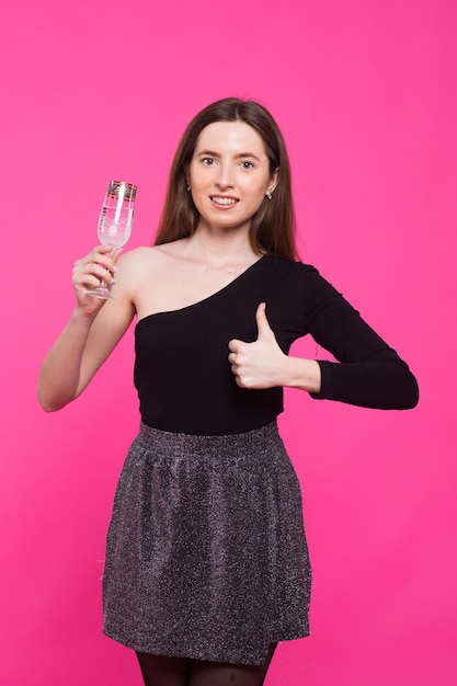 fiesta bebidas vacaciones navidad y gente concepto mujer sonriente en vestido de noche con vidrio