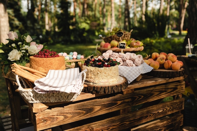 En la fiesta de bodas hay deliciosos pasteles y melocotones dulces y otras frutas diferentes.