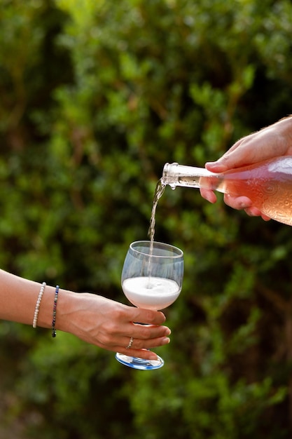 Fiesta con una botella de champán Espumoso en una fiesta de botellas Espumoso se vierte en una copa Vacaciones