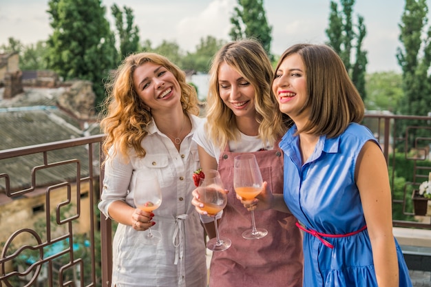 Fiesta de chicas. Hermosas mujeres amigas en el balcón divirtiéndose en la despedida de soltera