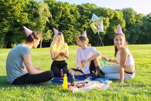 Fiesta de cumpleaños de adolescentes picnic en el césped del parque