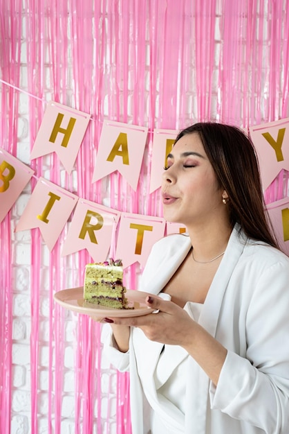 Foto fiesta de cumpleaños mesas de cumpleaños mujer morena atractiva en ropa de fiesta blanca preparando mesa de cumpleaños con pasteles cakepops macarons y otros dulces pidiendo deseo