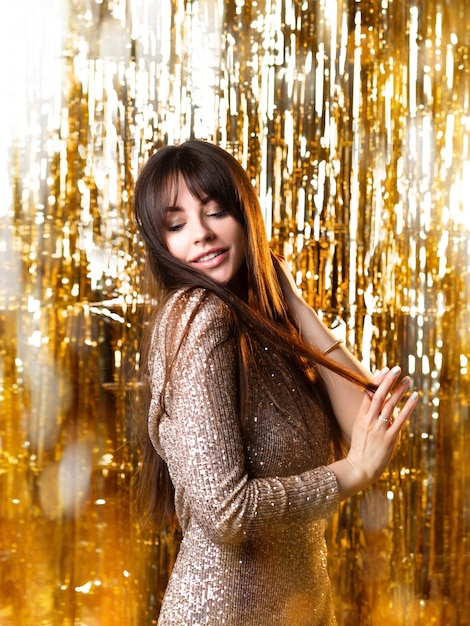 Fiesta de cumpleaños o año nuevo una mujer joven con un vestido de lentejuelas brillante sonríe