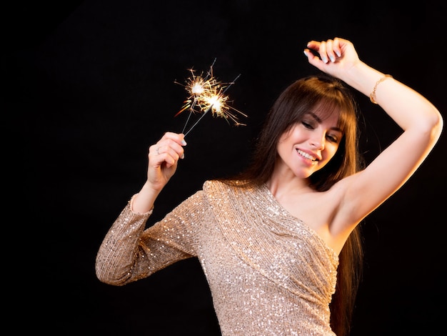 Fiesta de cumpleaños o nochevieja joven hermosa morena con un vestido dorado